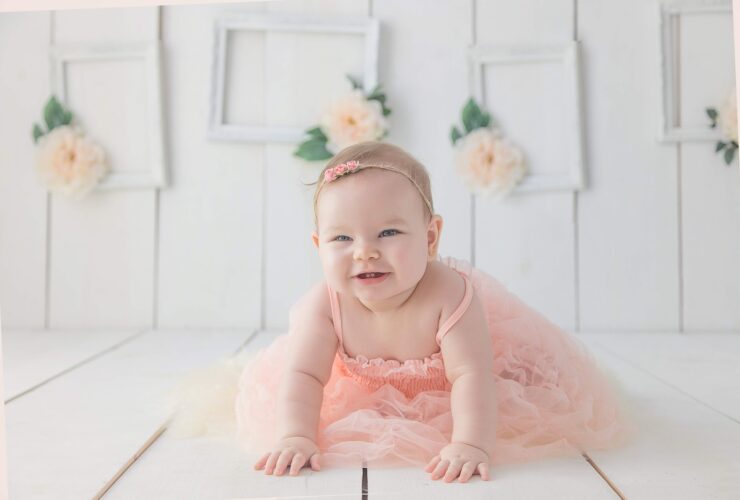 girl crawling on white floor while smiling