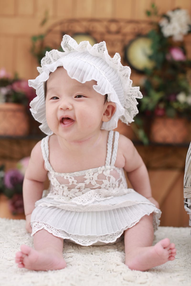 Baby in White Dress With White Headdress
