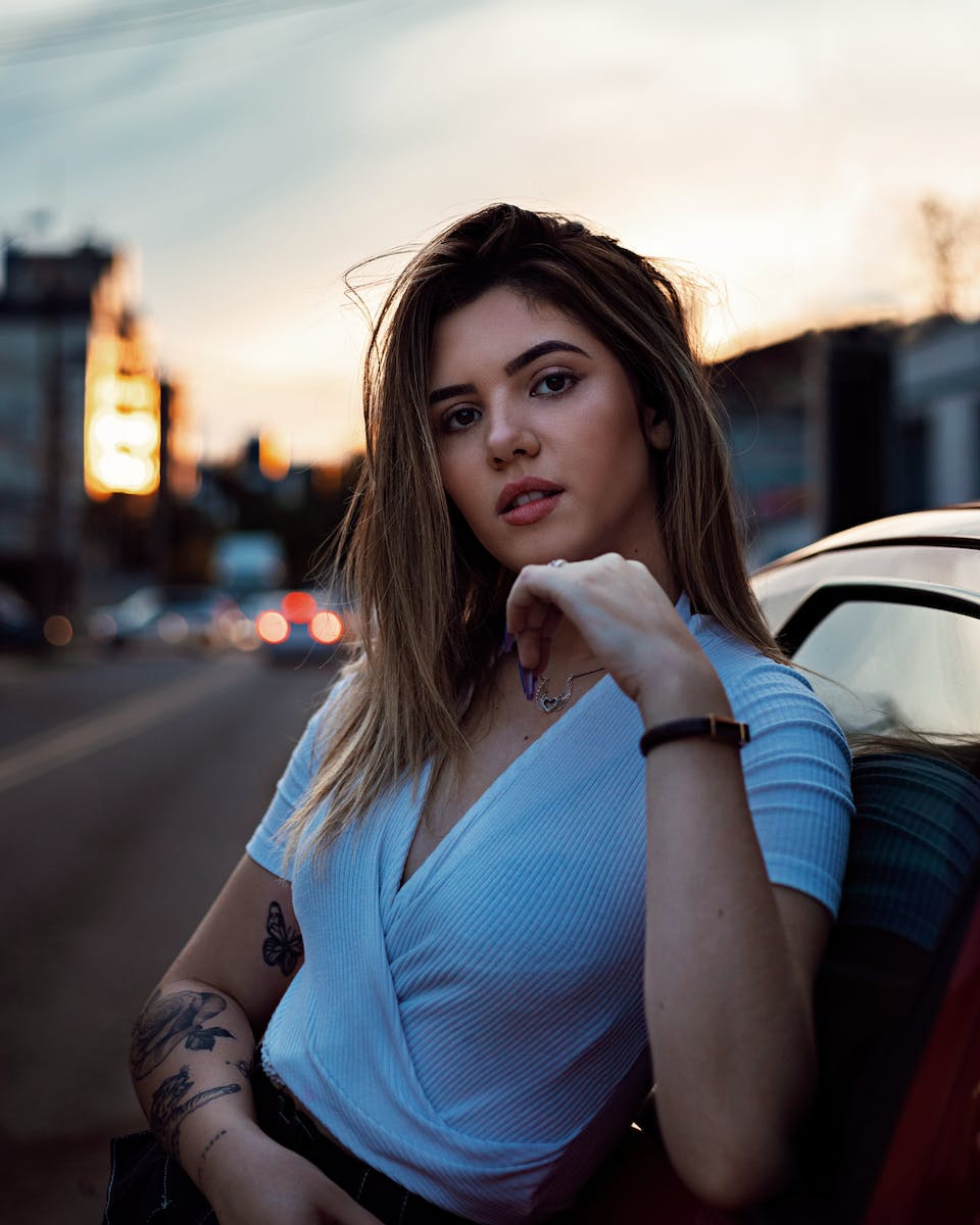 Close-up Photo of Woman Leaning on Vehicle Posing