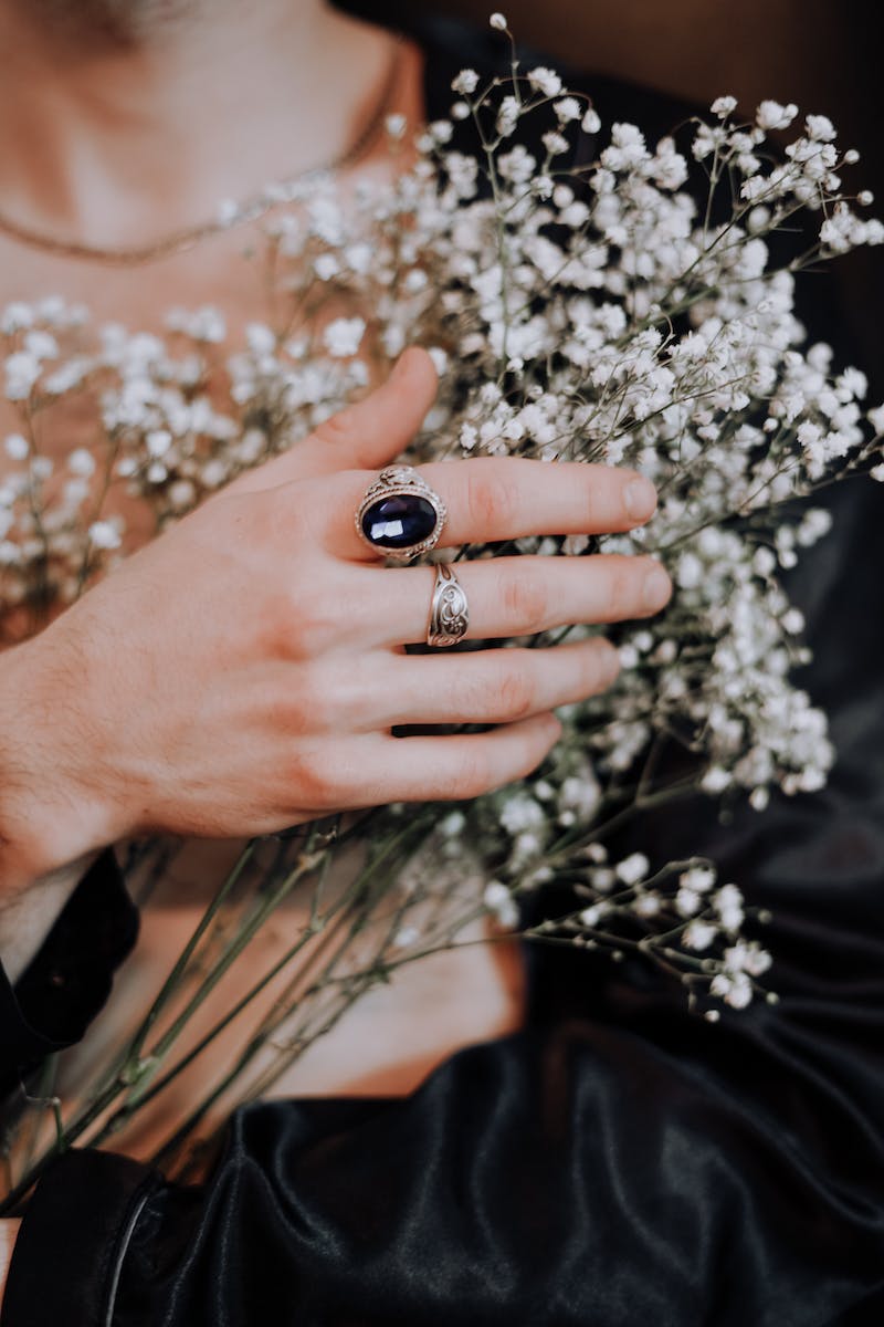 Person Wearing Silver Ring With Black Gemstone