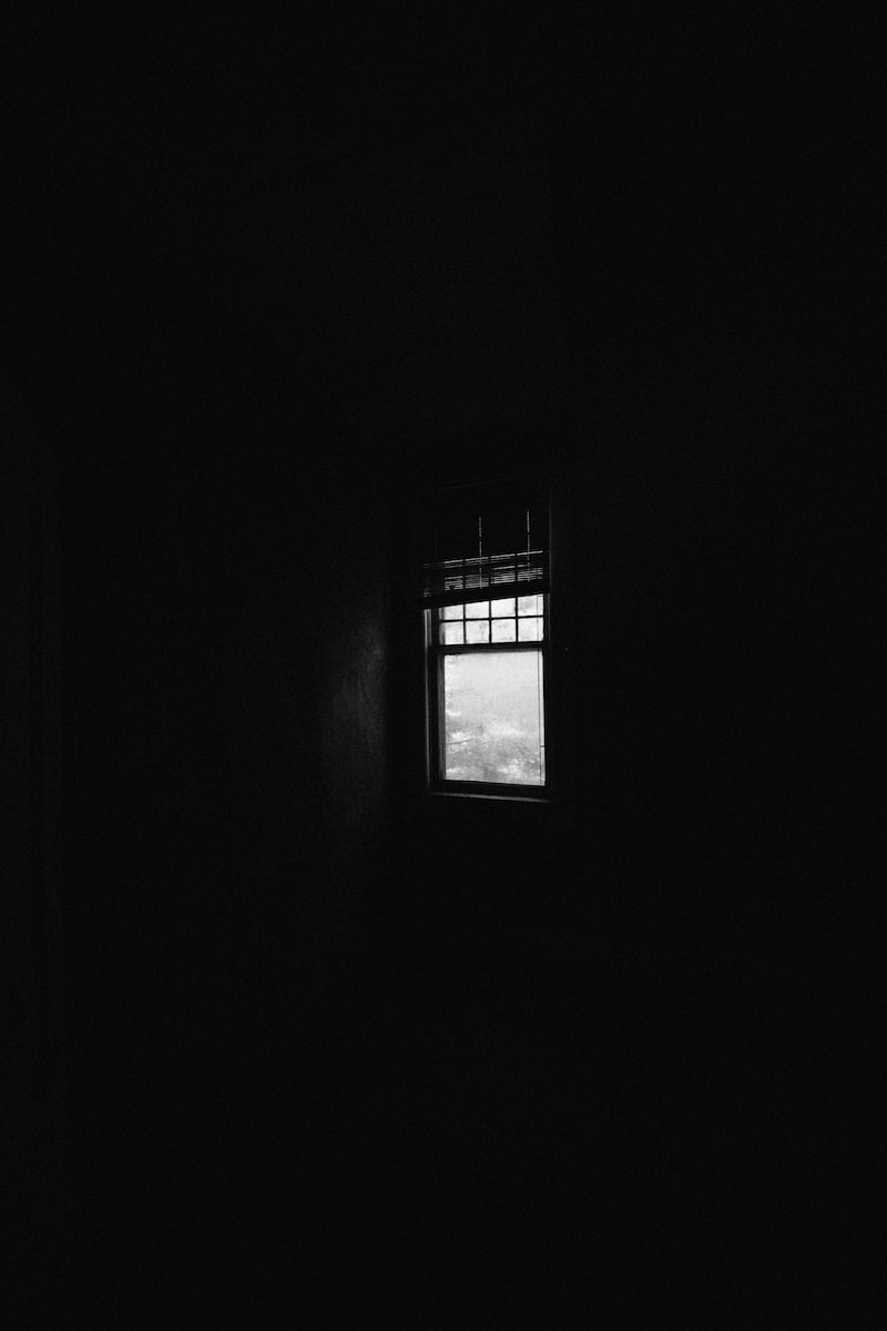 a window in a dark room with a sky view