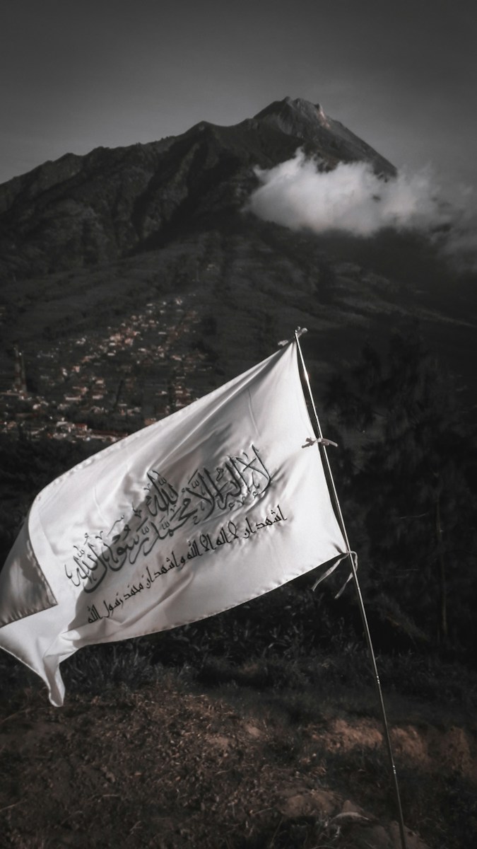 white and blue flag on mountain during daytime