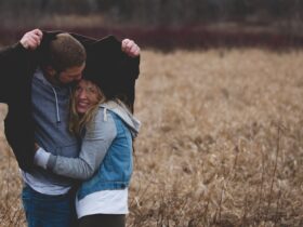 Man and Woman Hugging on Brown Field