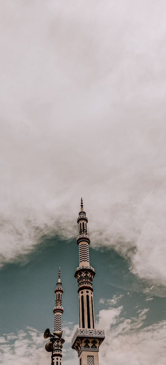 white and brown concrete tower under white clouds