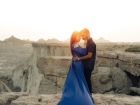 a man and a woman are kissing on a rock