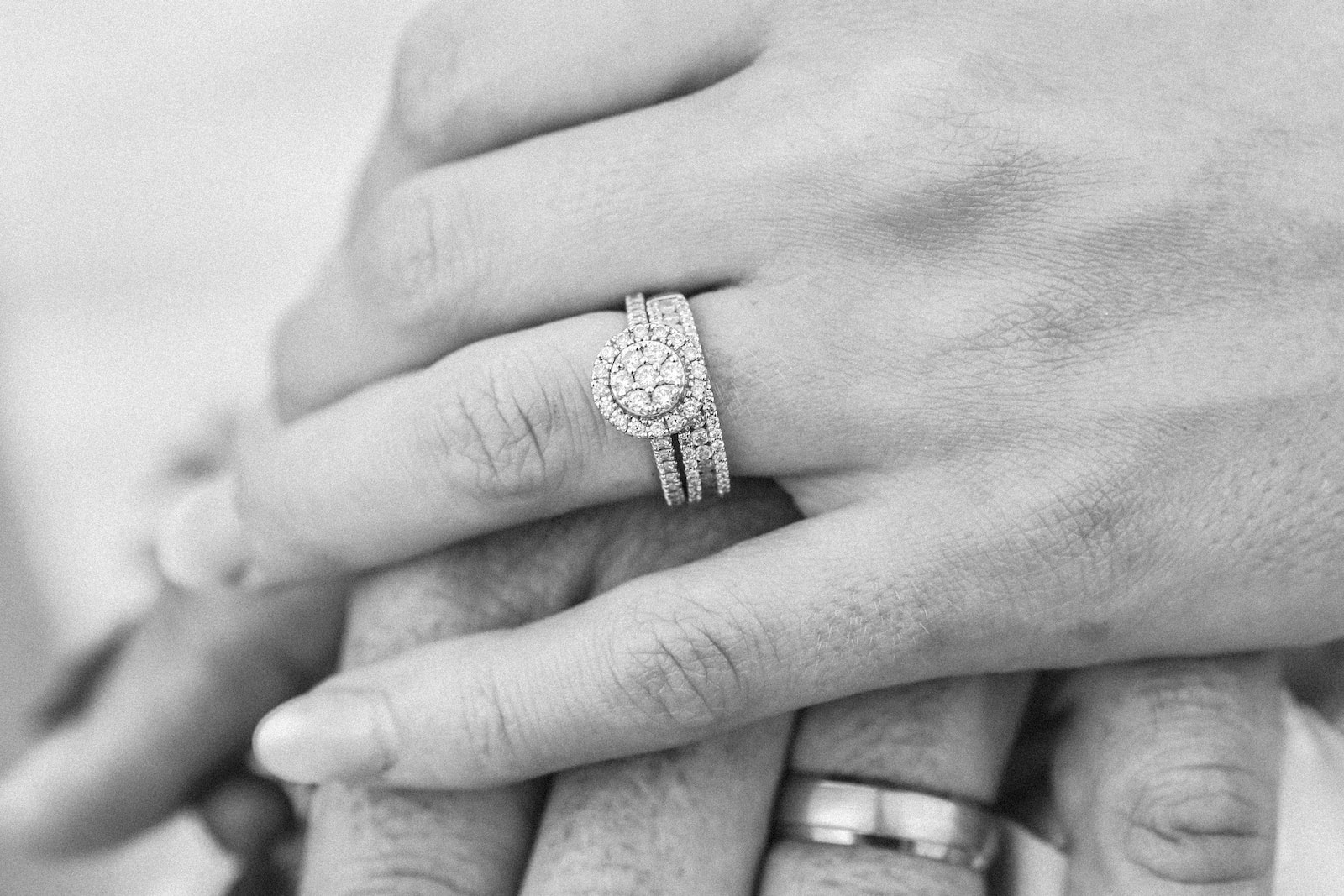 grayscale photo of two hands with rings