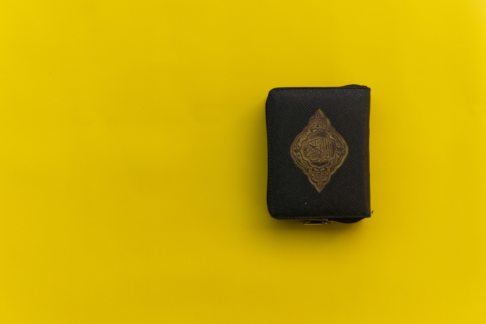 black leather wallet on yellow surface