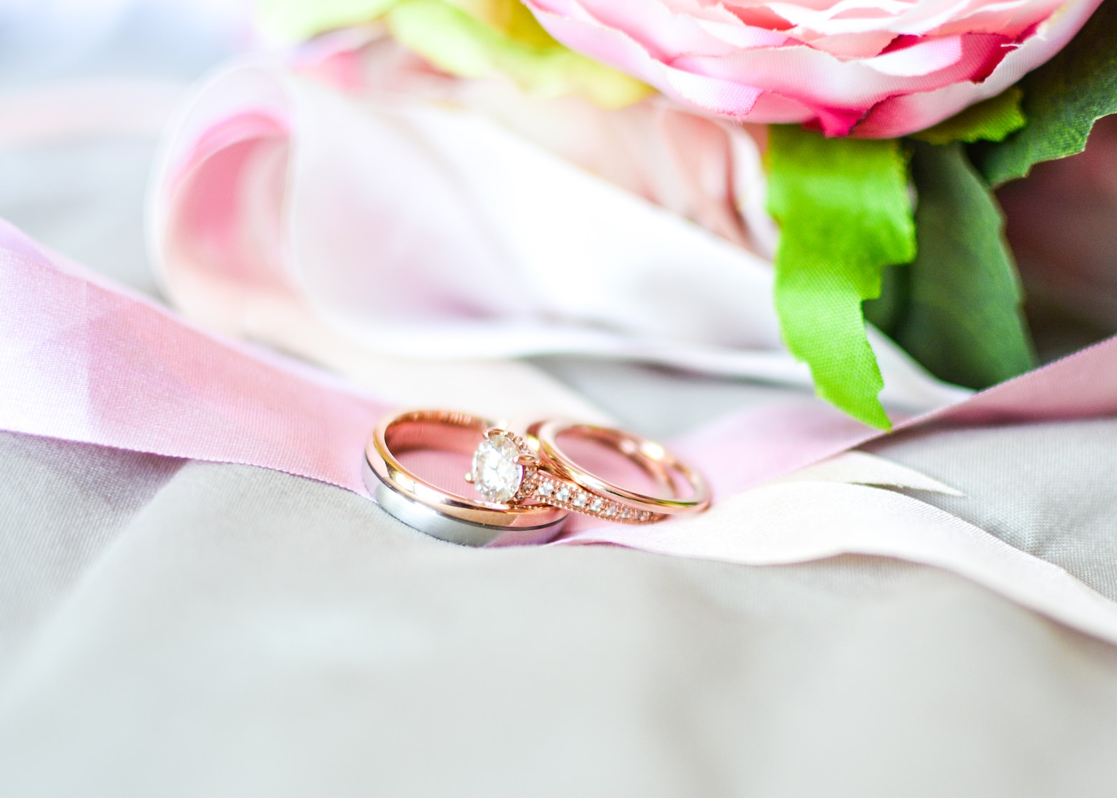 silver-and-gold-colored rings near pink flower
