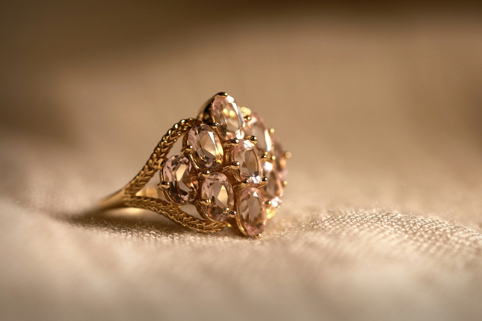 gold diamond studded ring on white textile