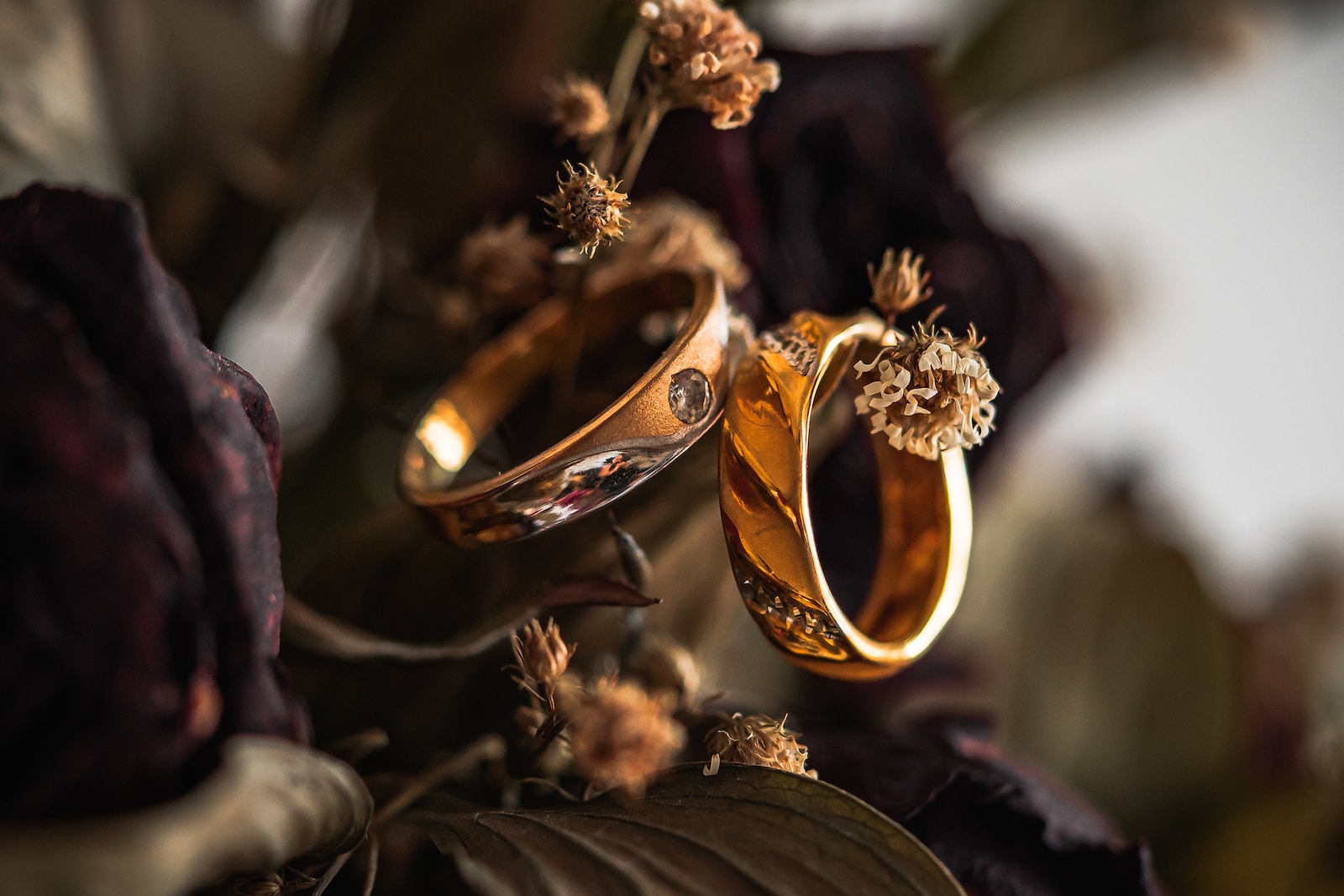 gold wedding band on brown leaves