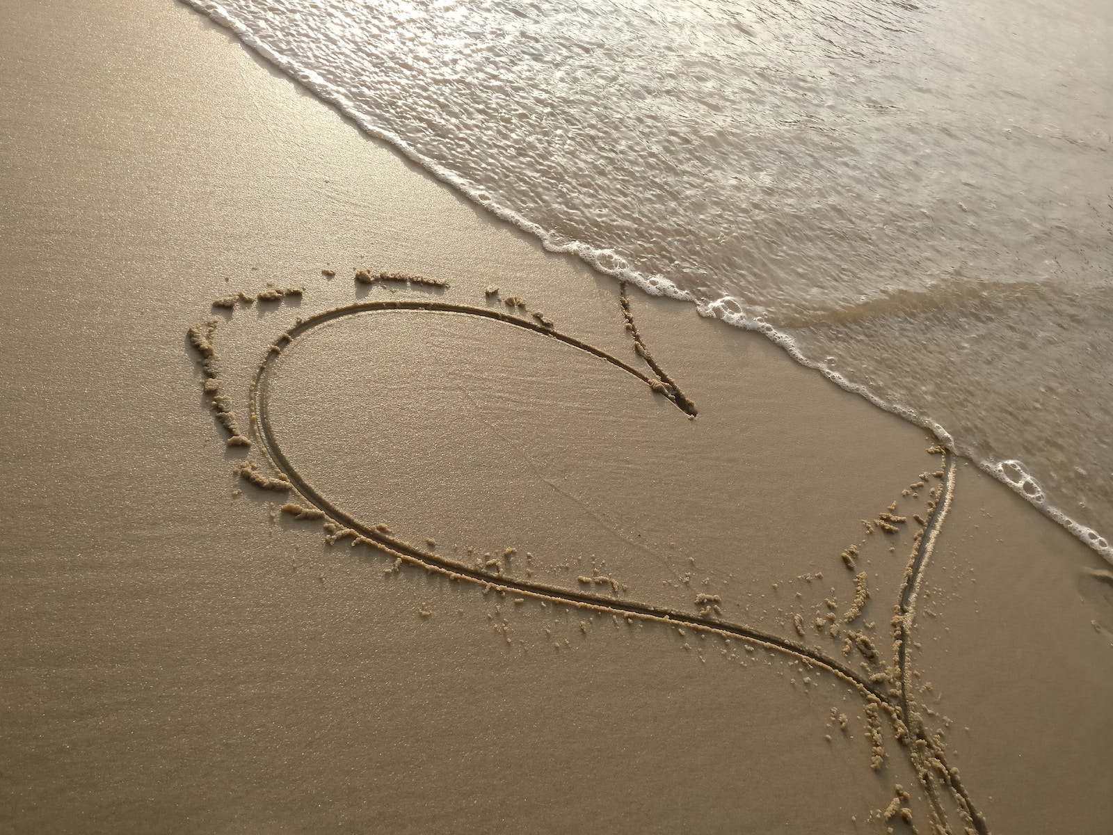 handwritten heart on sand