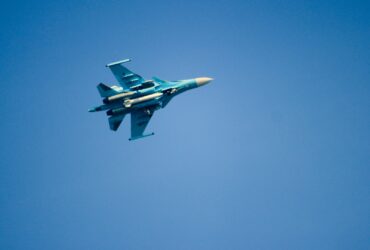 blue and white jet plane in mid air during daytime