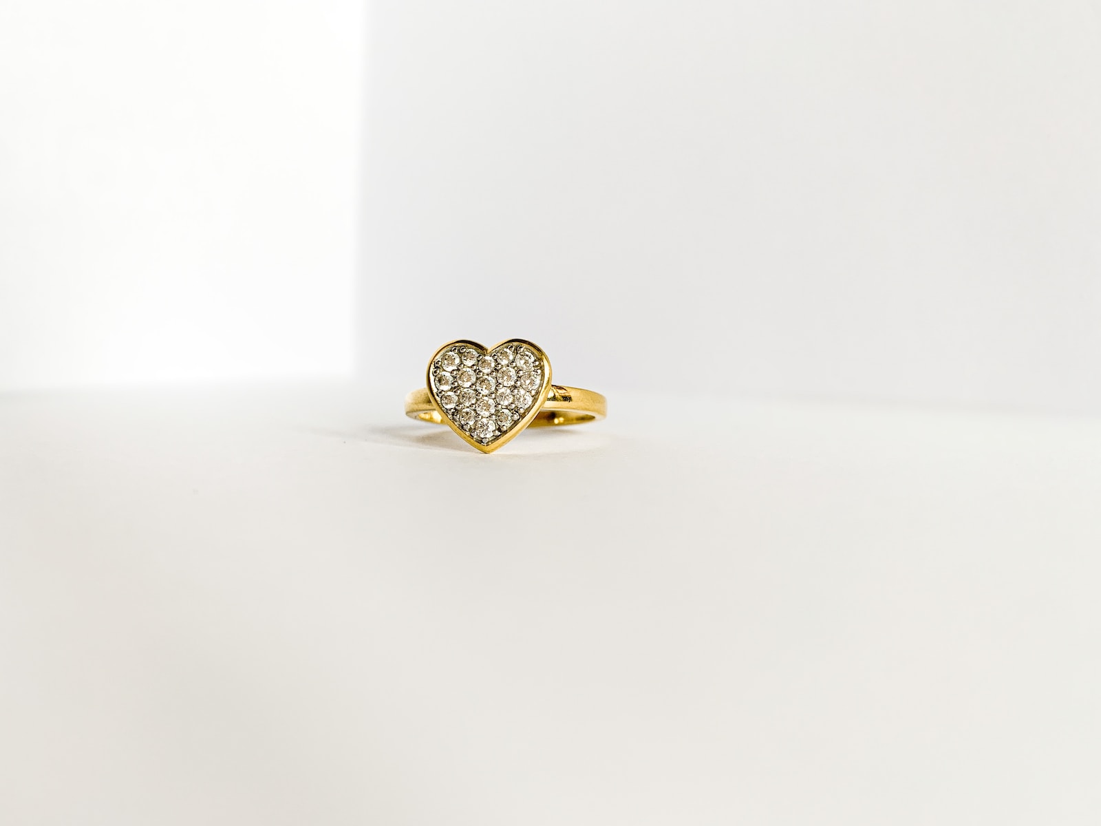 gold diamond ring on white surface