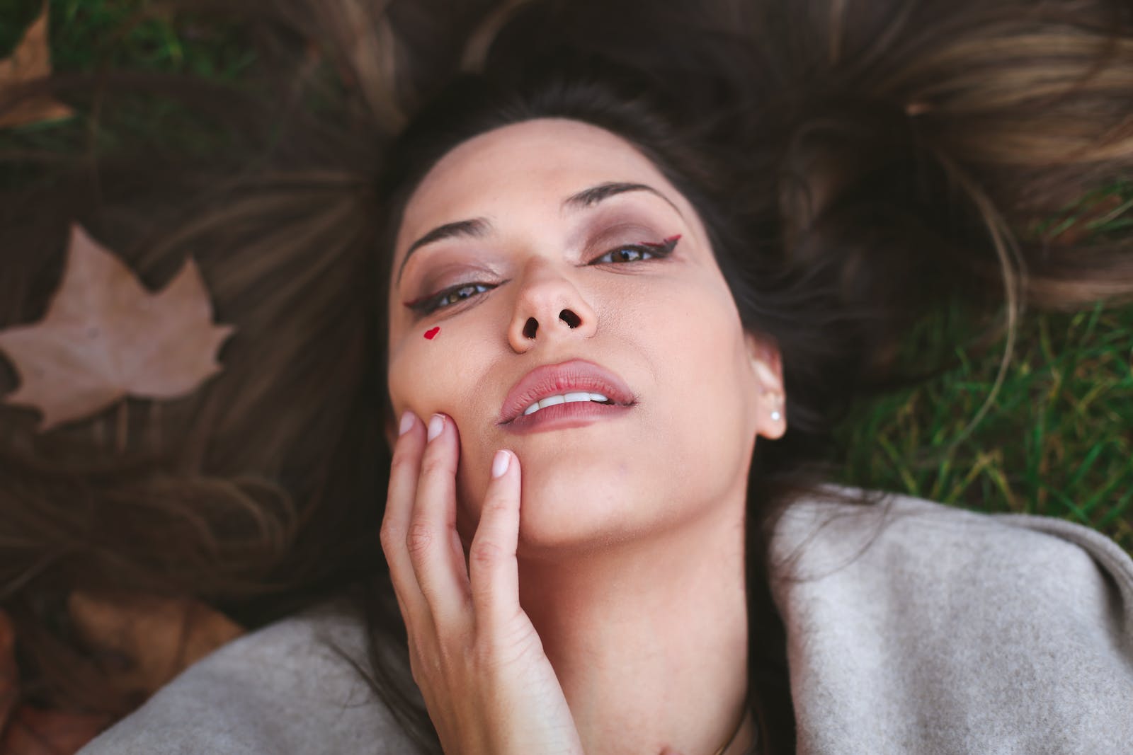 A woman laying on the ground with her eyes closed
