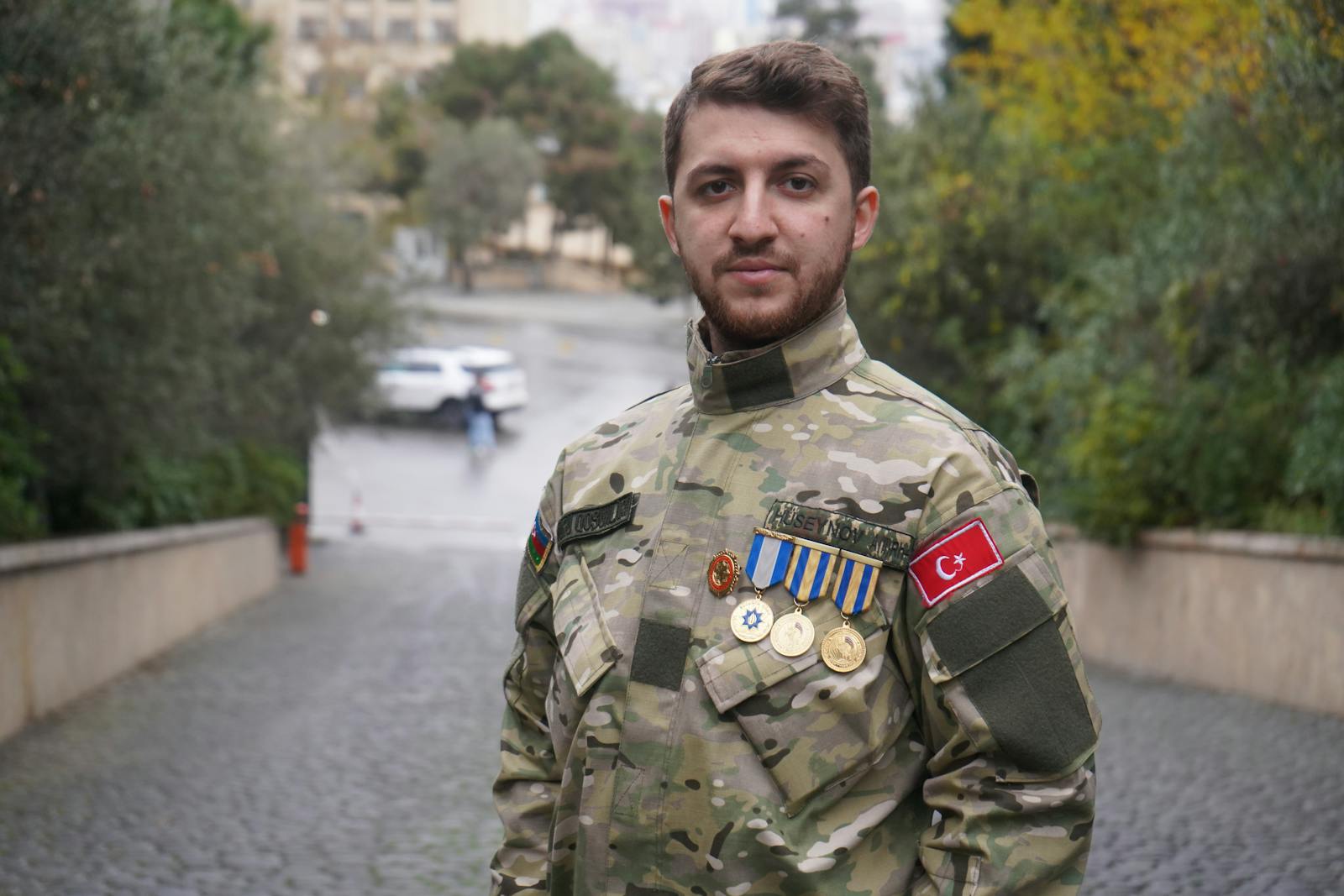 A military officer proudly wearing a uniform with medals in Baku, Azerbaijan.